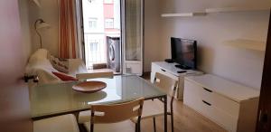 sala de estar con mesa de cristal y TV en 3 Bedrooms SOHO Parking Included, en San Sebastián