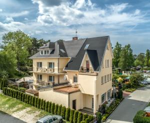 a large white house with a black roof at D.L.Błażkiewicz in Mielno