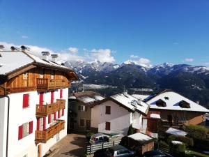 un gruppo di edifici con montagne innevate sullo sfondo di Appartamento Pezzol a Daiano