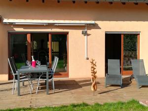 a patio with a table and chairs on a deck at L'Ours Vert in Baerenthal