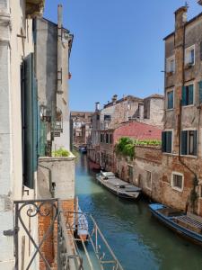 a canal between two buildings with boats in the water at Canaletto Apartments in Venice