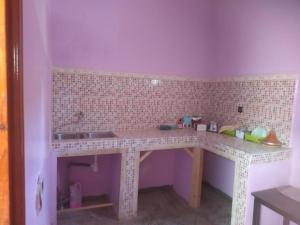 uma pequena cozinha com um balcão e um lavatório em Chez l'habitant (Ba Omar) em Zagora