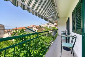 a balcony with a table and chairs on a building at Apartments Vjeko in Makarska