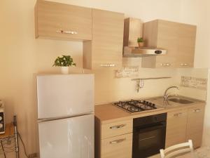 una cucina con frigorifero bianco e lavandino di Villetta Negroni a Gallipoli