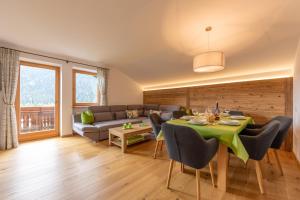 salon ze stołem i kanapą w obiekcie Residence Tamperhof w mieście San Candido