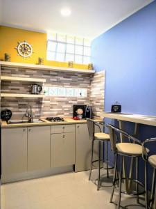 a kitchen with a counter and stools in it at B&B L'Edera di Caterina in Reggio di Calabria