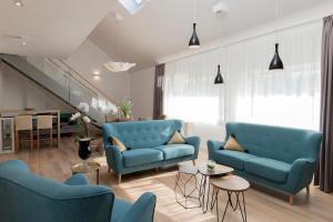 a living room with blue chairs and a staircase at Millennium apartments in Čakovec