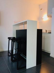 a kitchen with a white counter and a table and stool at Nice Promenade 1 in Nice