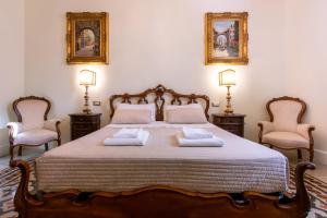 een slaapkamer met een groot bed en 2 stoelen bij Sant'Ivo Apartments in Rome