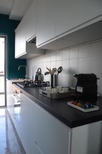 a kitchen with white cabinets and a black counter top at JULIA LUXURY SUITE in Udine