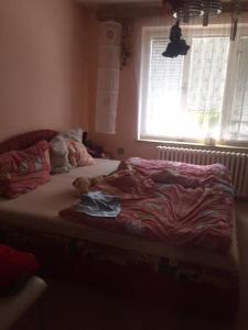 a bedroom with a bed with a stuffed animal on it at Apartmán in Dolní Bukovsko