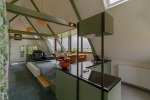 een open keuken en een woonkamer met groene kasten bij B&B Weids in Elst