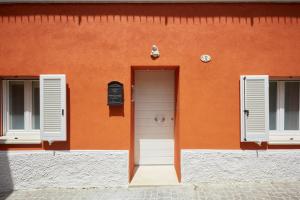 - un bâtiment orange avec une porte et deux fenêtres dans l'établissement Affittacamere Somnium, à Sirolo