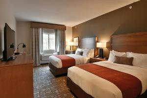 a hotel room with two beds and a television at GrandStay Hotel & Suites in Sisters +14 photos