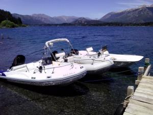 two boats are docked on a body of water at Casa de campo con costa de lago in San Carlos de Bariloche