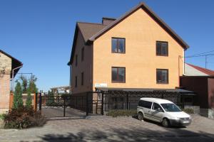 una camioneta blanca estacionada frente a una casa en U House Apart-Hotel Poltava сучасні апартаменти в центрі, en Poltava