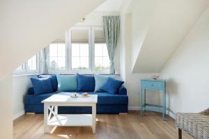Villa Sedina في ريفال: غرفة معيشة مع أريكة زرقاء وطاولة
