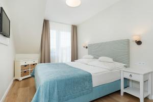 a white bedroom with a bed and a window at Villa Sedina in Rewal