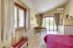 1 dormitorio con 1 cama, mesa y sillas en Le Mas des Anges, en Cheval Blanc