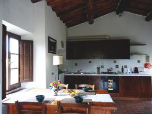 a kitchen with a table with chairs and a kitchen with a counter at Agriturismo Piemaggino in Castellina in Chianti