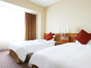 a hotel room with two beds and two lamps at Star Gate Hotel Kansai Airport in Izumi-Sano
