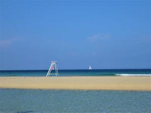 a beach with a metal structure in the middle of the water at Chambre d hôtes O beurre salé in Cléden-Cap-Sizun