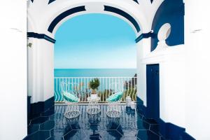 uma varanda com cadeiras e uma mesa e o oceano em Imperati Suites by Alcione Residence em Positano