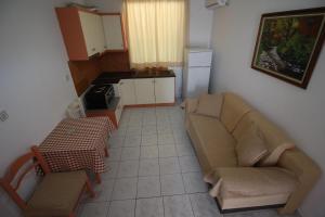 Mejdi Apartments في سارنده: غرفة معيشة بها أريكة وطاولة