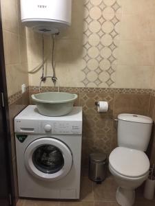 a washing machine with a bowl on top of it in a bathroom at Apartments Dione in Pomorie +32 photos