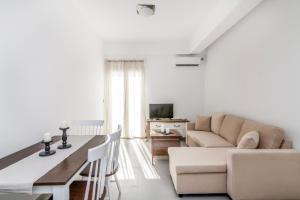 a living room with a couch and a table at Lux 'n Comfort Apartments in Tinos
