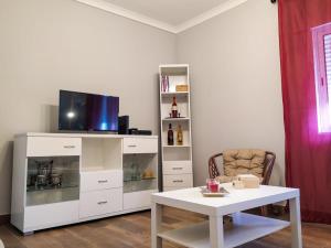a living room with a white entertainment center with a tv at Casa Vaz in Grândola