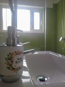 a bathroom with a sink and a bottle of light bath at Casa Vaz in Grândola