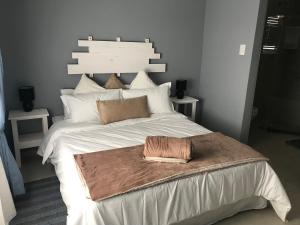 a bedroom with a large white bed with a brown blanket at Bella Luna Bed and Breakfast in Walvis Bay