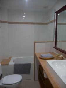 a bathroom with a toilet and a sink and a tub at CARROS 19 in Vilanova i la Geltrú