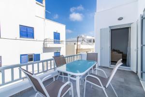 a balcony with a blue table and chairs at Lux 'n Comfort Apartments in Tinos