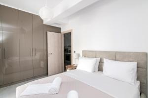 a bedroom with a large white bed with white pillows at Lux 'n Comfort Apartments in Tinos