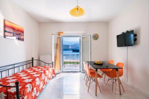 a bedroom with a bed and a table with chairs at Metela apartment in Argostoli
