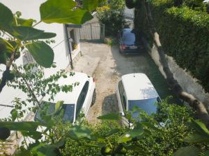 twee auto's geparkeerd op de oprit van een huis bij Villa de Ros in Salò