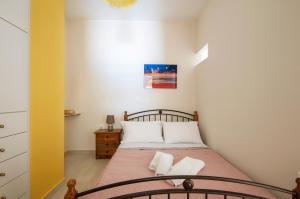 a small bedroom with a bed with white pillows at Metela apartment in Argostoli
