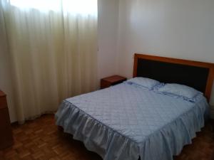 a bedroom with a bed with a white comforter at Vila do Conde Holidays Flat in Areia