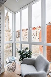 sala de estar con sofá y ventana grande en APARTAMENTOS ELEVEN ROOMS, en Burgos