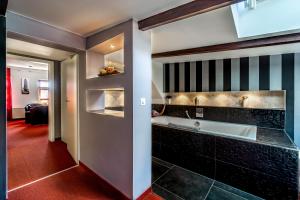 ein Badezimmer mit einer Badewanne und einem Waschbecken in der Unterkunft SL'otel - Das Stadthotel in Bernburg