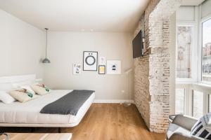 een slaapkamer met een bed en een bakstenen muur bij APARTAMENTOS ELEVEN ROOMS in Burgos