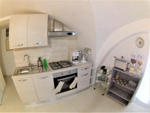 a small kitchen with a stove and a sink at Landolina Sweet Home in Catania
