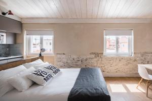 una camera da letto con un grande letto bianco e due finestre di RICE Eleven Rooms a Burgos