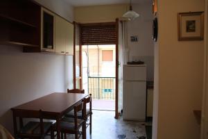 een keuken met een tafel en stoelen en een open deur bij INTERNO 12 in Varazze