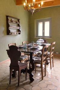 una sala da pranzo con tavolo, sedie e lampadario pendente di Relais B ad Ancona