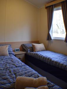 2 camas en una habitación con ventana en Chapel View Caravans, en Embleton