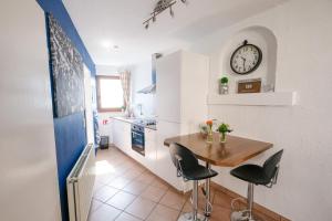 a kitchen with a table and a clock on the wall at Sweet&City STUDIO in Saint-Vith