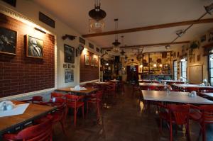 um restaurante com mesas de madeira e cadeiras vermelhas em Prohibicja Peter's Pub em Mikolajki